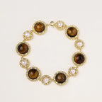 Gold-plated link bracelet with alternating brown tiger's eye stones and white freshwater pearls in ornate bezels.