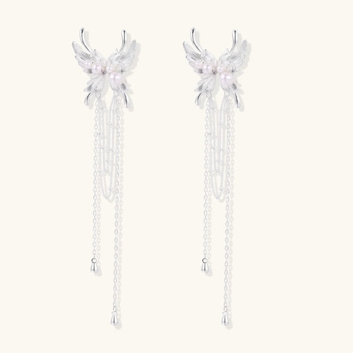 Elegant chandelier earrings with phoenix wing design, white pearls, and cascading silver chains on cream background