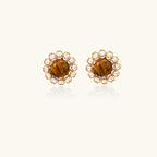 Gold-plated stud earrings with cushion-cut tiger's eye stones surrounded by pearl halos on white background.