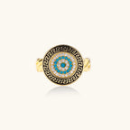 Gold chain ring with Greek key border and turquoise evil eye center on white background