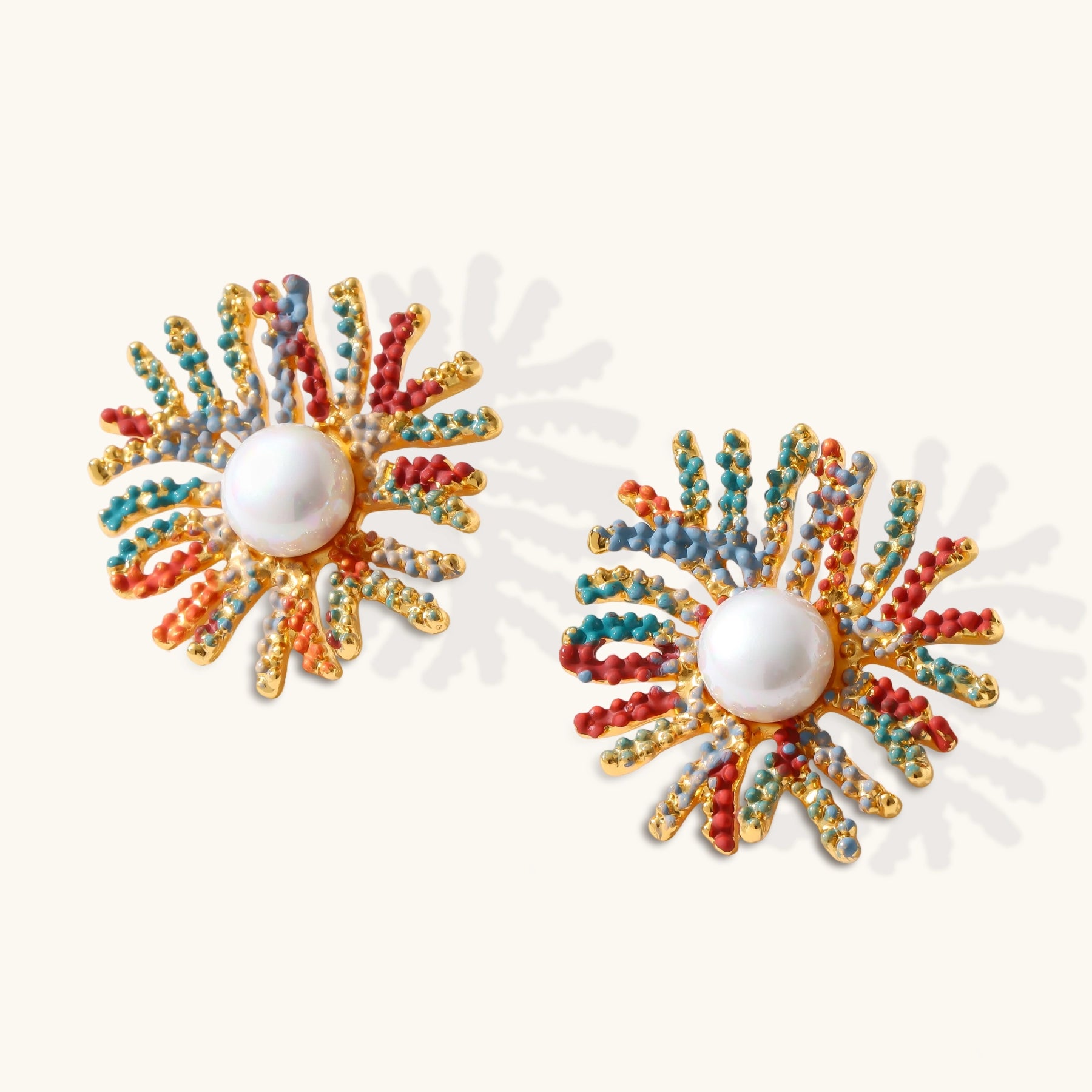Vibrant starburst stud earrings with multicolor enamel rays and white pearl centers on gold-plated setting