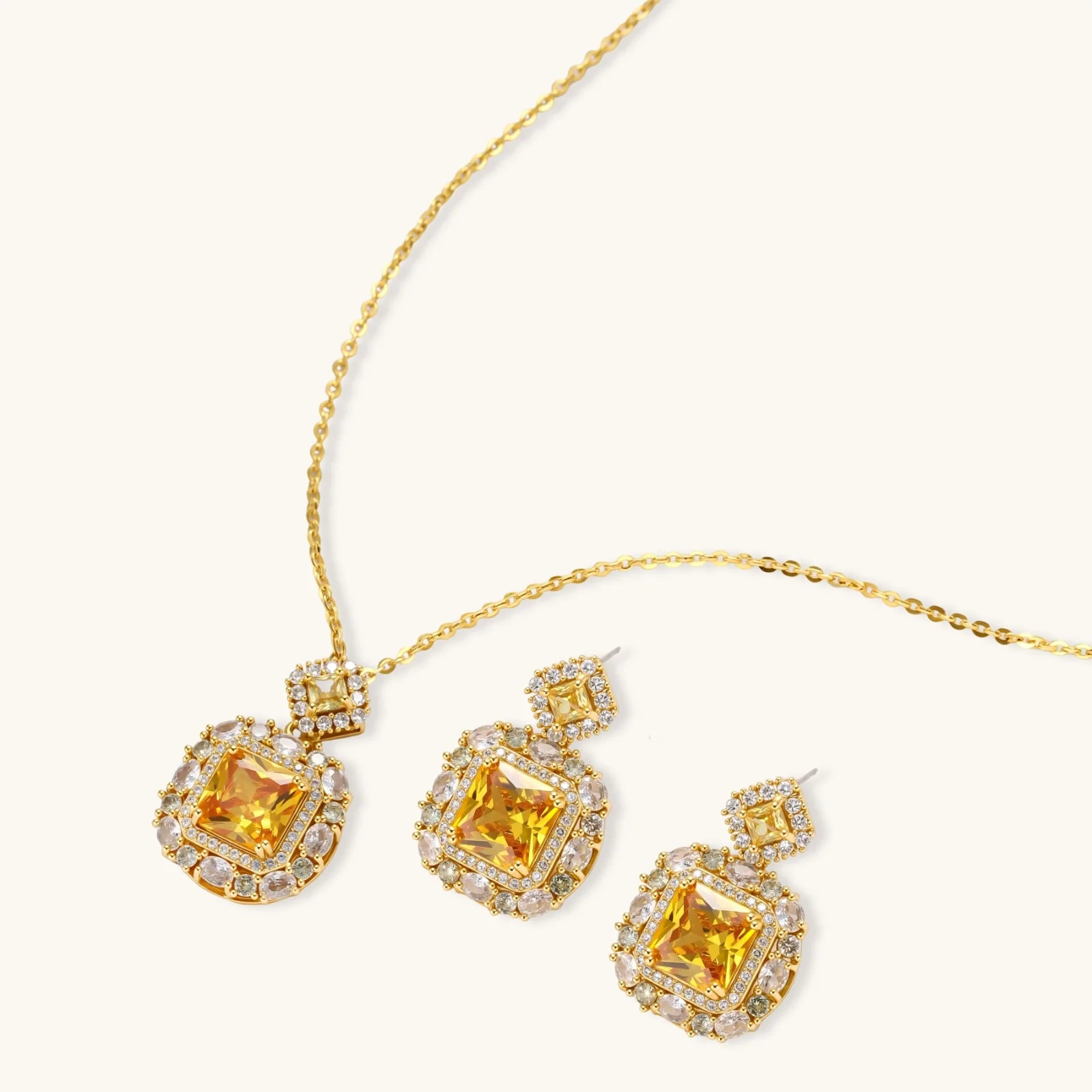 14K gold-plated jewelry set featuring square-cut cubic zirconia stones in ornate layered settings on white background.