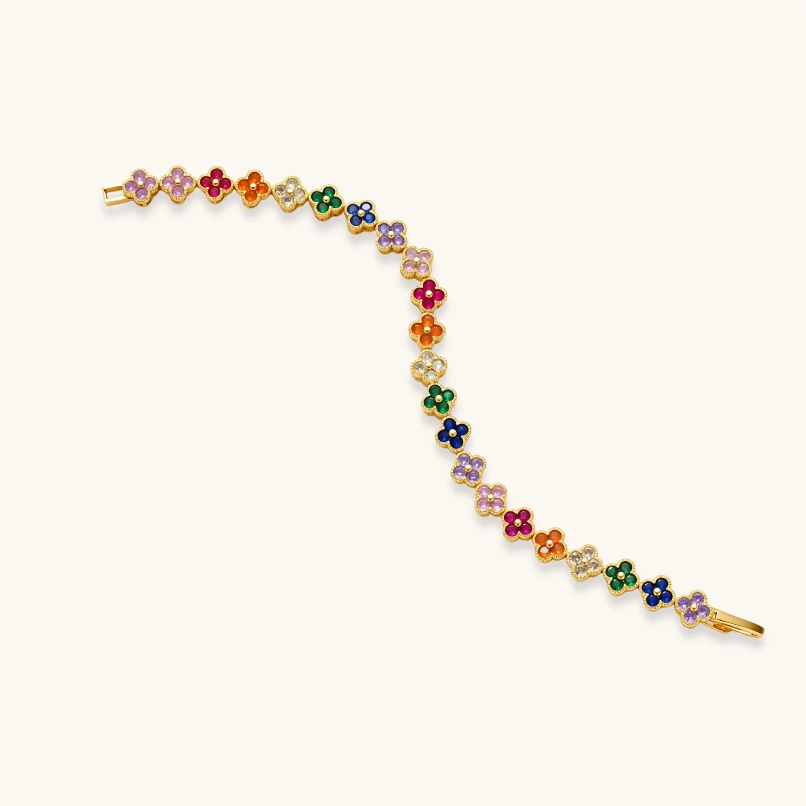 Colorful four-leaf clover jewelry set with rainbow cubic zirconia stones in gold-plated setting on white background