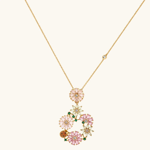 14K gold plated jewelry set with pink and green cubic zirconia flowers arranged in wreath design on cream background