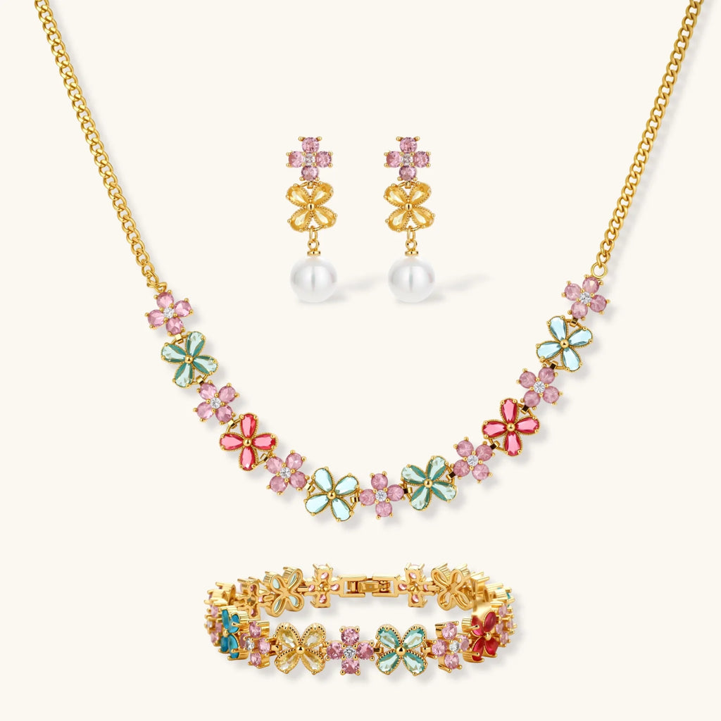 Gold-plated jewelry set with pink, turquoise and red flower-shaped cubic zirconia stones, featuring necklace, earrings and bracelet.