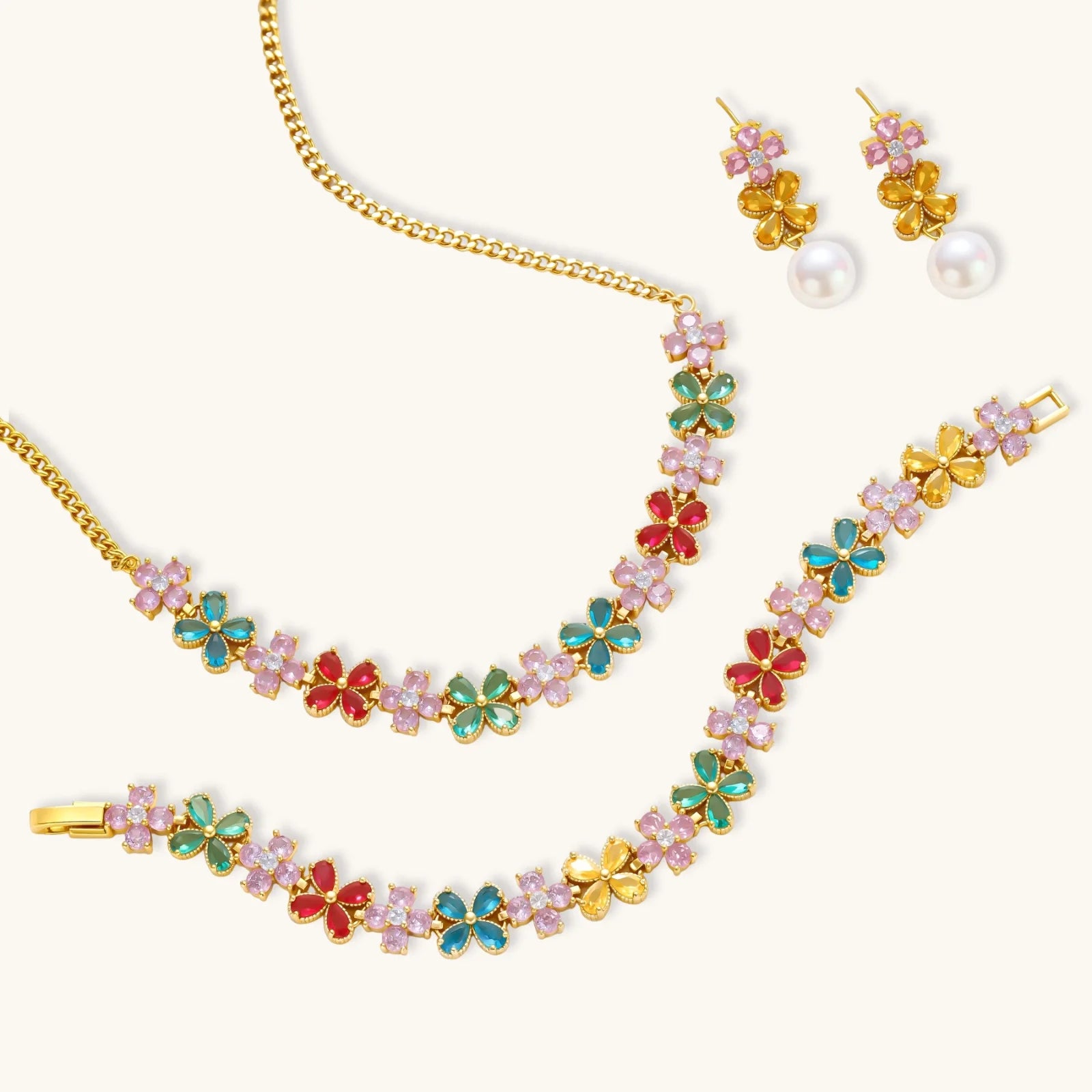 Gold-plated jewelry set with pink, turquoise and red flower-shaped cubic zirconia stones, featuring necklace, earrings and bracelet.