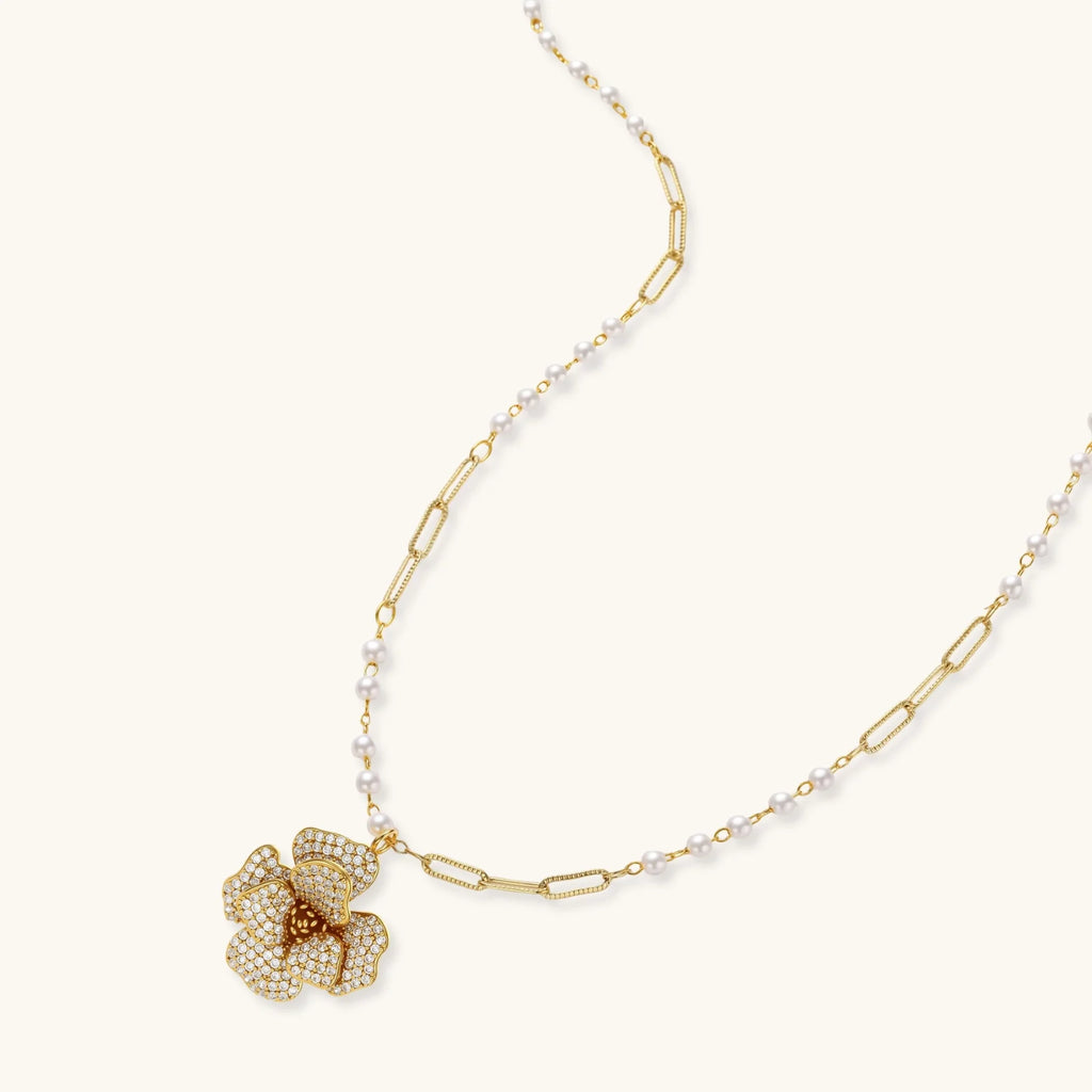 14K gold-plated floral jewelry set with blue cubic zirconia centers and pearl chain details on white background.
