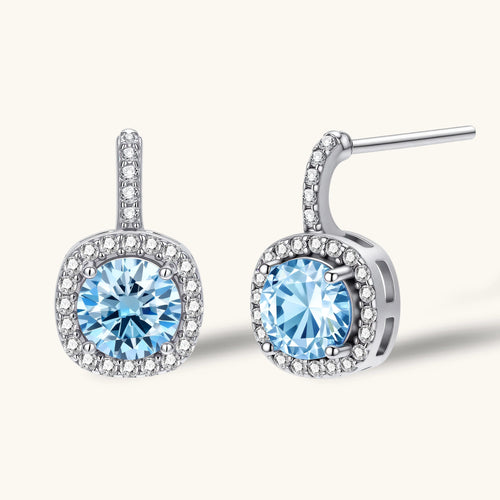 Sterling silver drop earrings featuring cushion-cut blue moissanite stones surrounded by sparkling halo settings