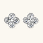 Dainty sterling silver quatrefoil stud earrings with four brilliant moissanite stones and center accent on white background.