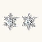 Sterling silver snowflake stud earrings with brilliant moissanite centers and intricate geometric patterns on cream background