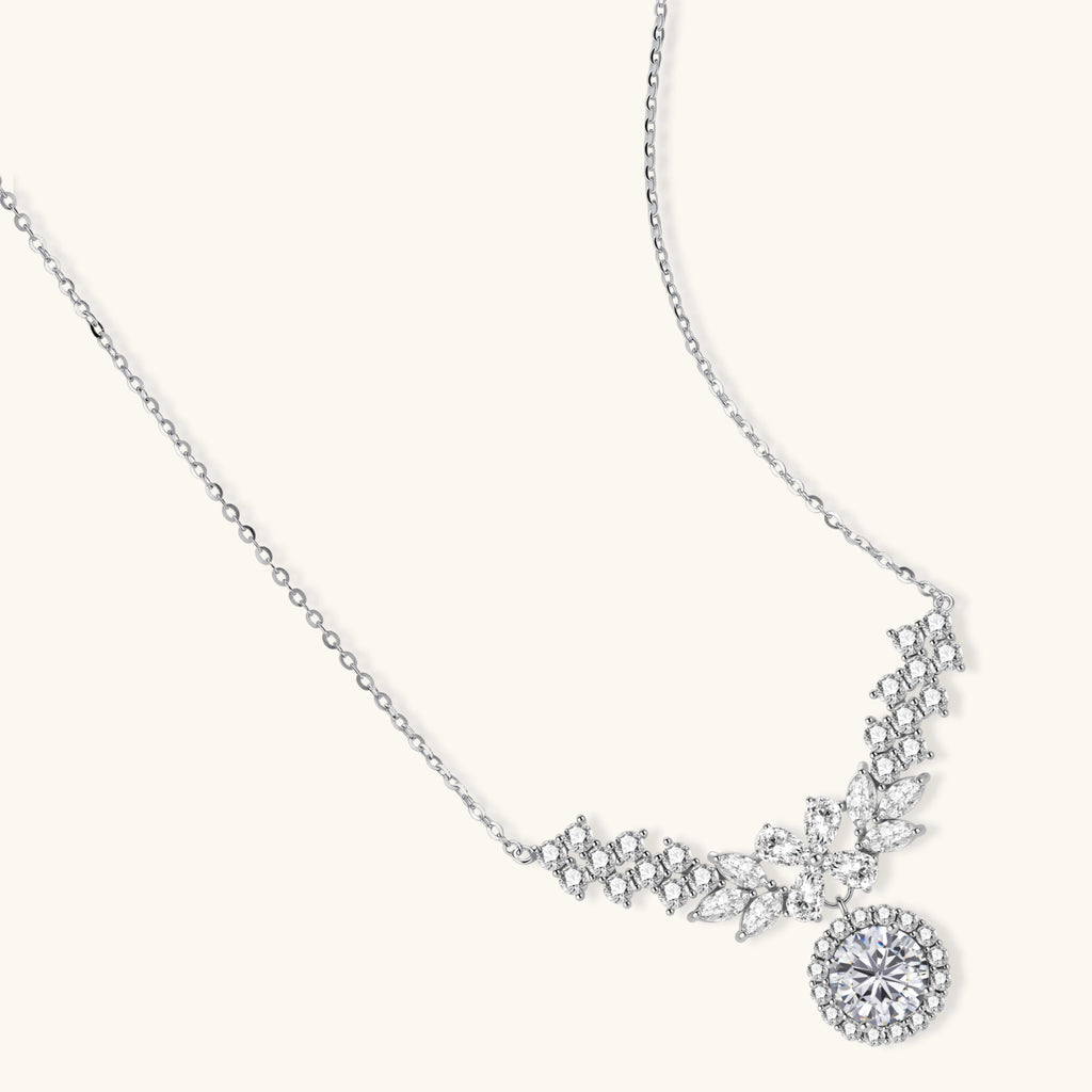 Elegant sterling silver necklace featuring intricate wing-like design with brilliant moissanite stones on neutral background.