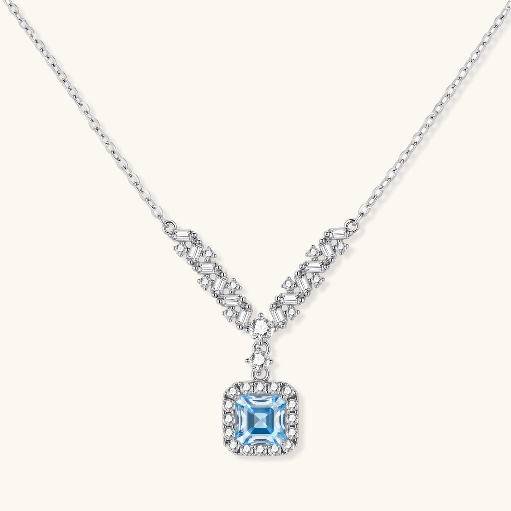 Sterling silver necklace with geometric crystal arrangement forming a V-shape and square blue moissanite centerpiece pendant
