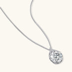 Sterling silver necklace featuring a large pear-shaped moissanite stone in an ornate setting with smaller accent stones