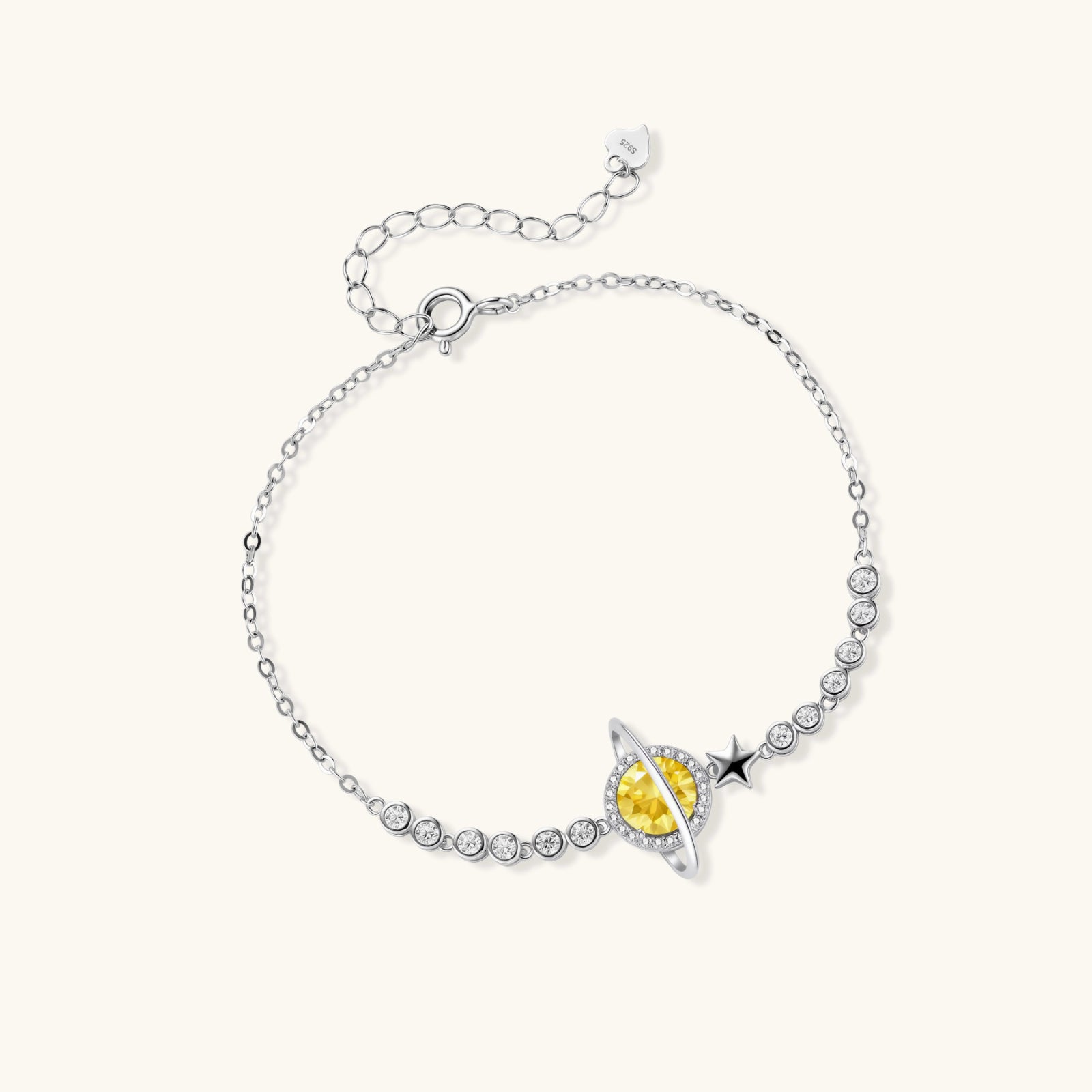 Sterling silver bracelet with yellow moissanite centerpiece in oval setting, crystal chain, and star charm on white background.