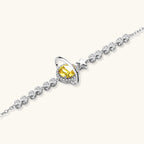 Sterling silver bracelet with yellow moissanite centerpiece in oval setting, crystal chain, and star charm on white background.