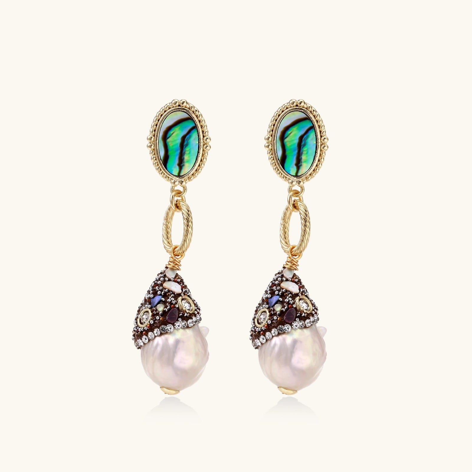 Gold drop earrings with iridescent abalone studs, rope links, jeweled caps and white baroque pearls on cream background