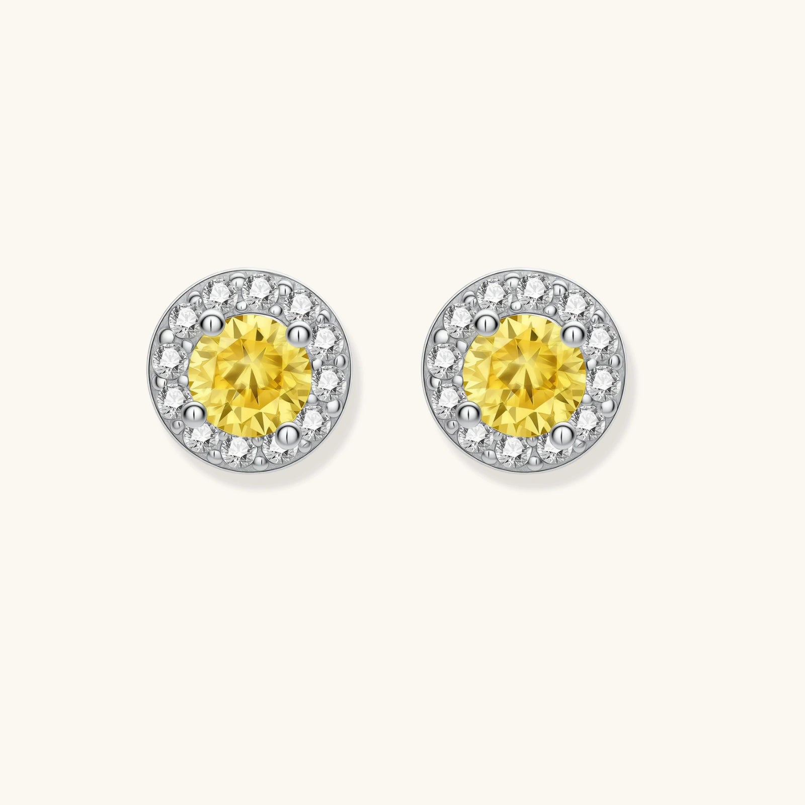 Dainty sterling silver stud earrings with yellow moissanite center stones surrounded by white halo stones