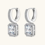 Sterling silver huggie hoops with emerald-cut moissanite drops featuring pavé-set crystals on white background.