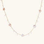 Gold vermeil chain with iridescent star-shaped baroque pearls and small round freshwater pearl drops on cream background.