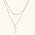 Three-layered gold necklace set with graduated cross pendants in mixed chain styles on white background.